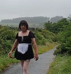 Femme de ménage travestie dans une voie publique sous polar pluie